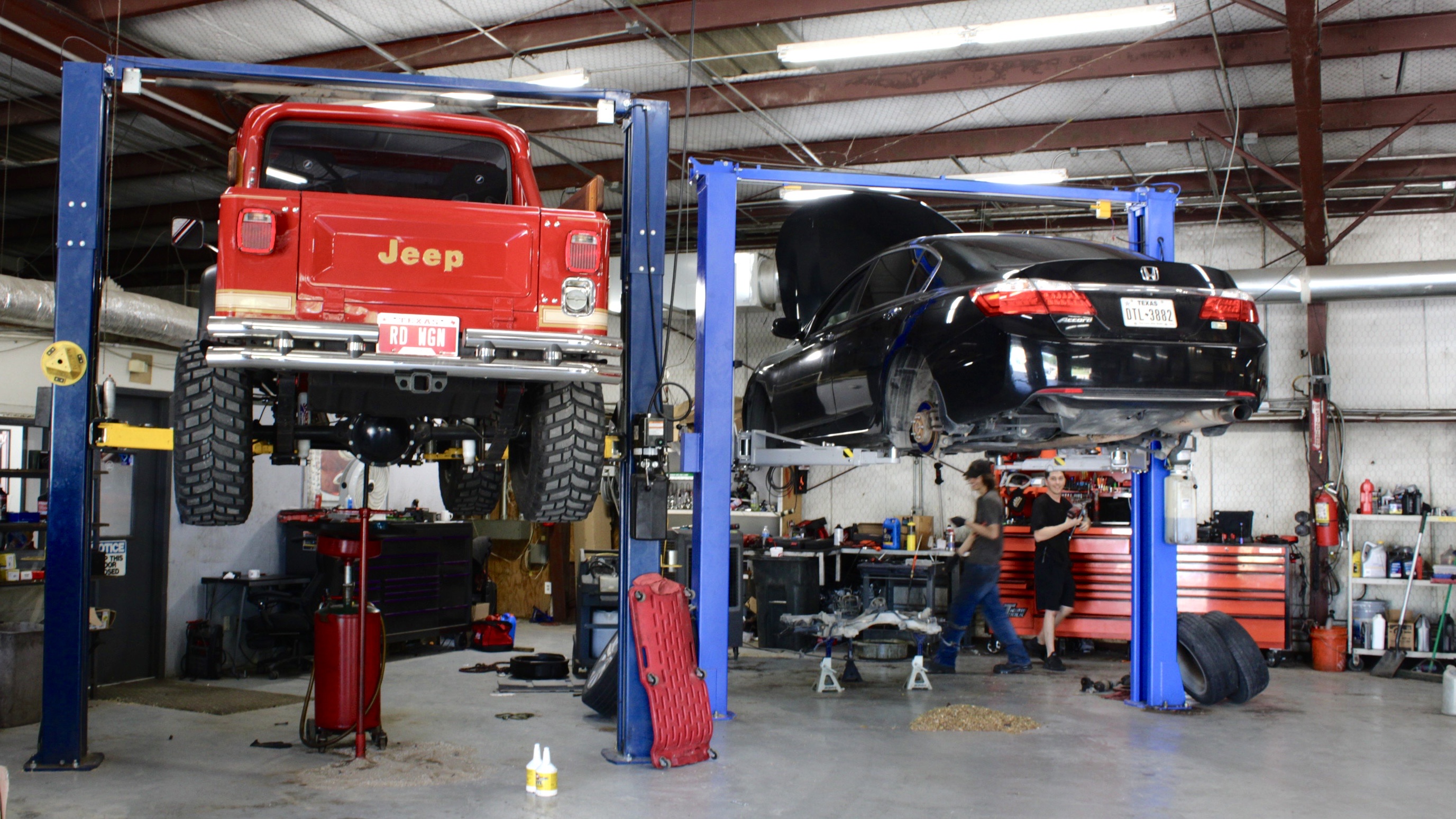 Interior of Willard Automotive Lewisville repair shop with vehicles in service bays 