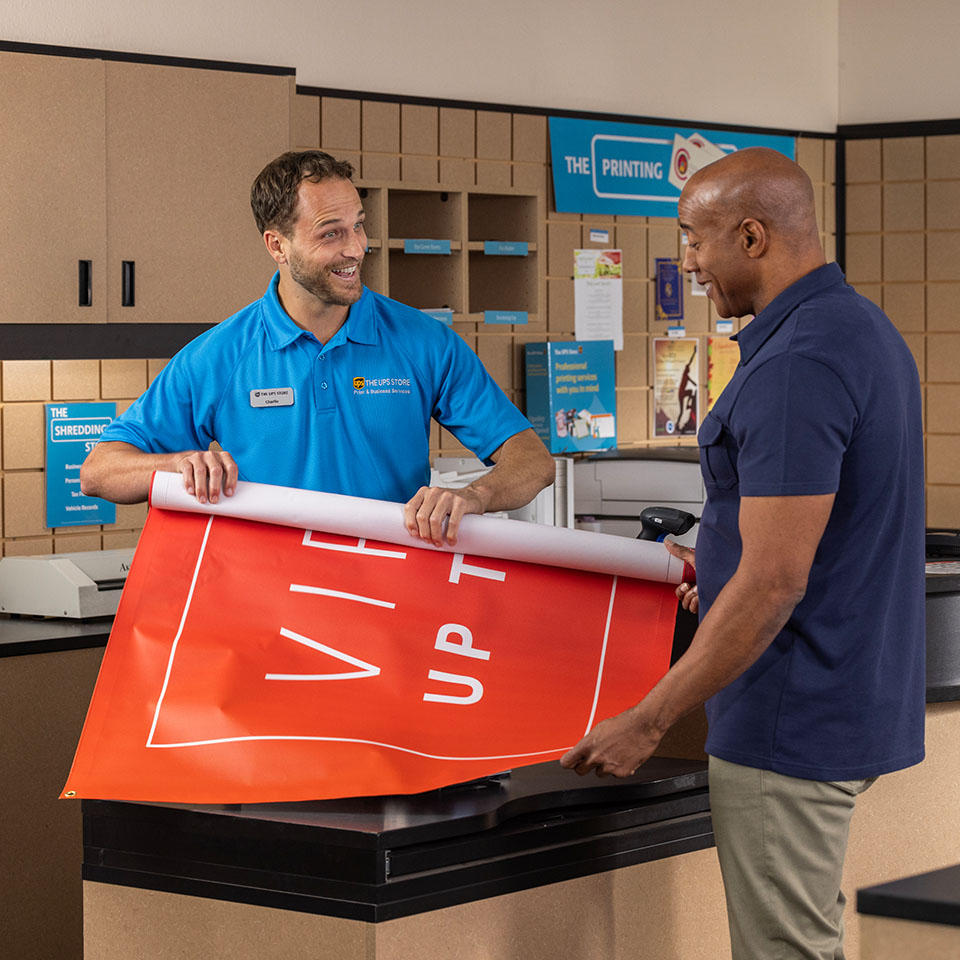 UPS Store Associate assisting customer with banner printing