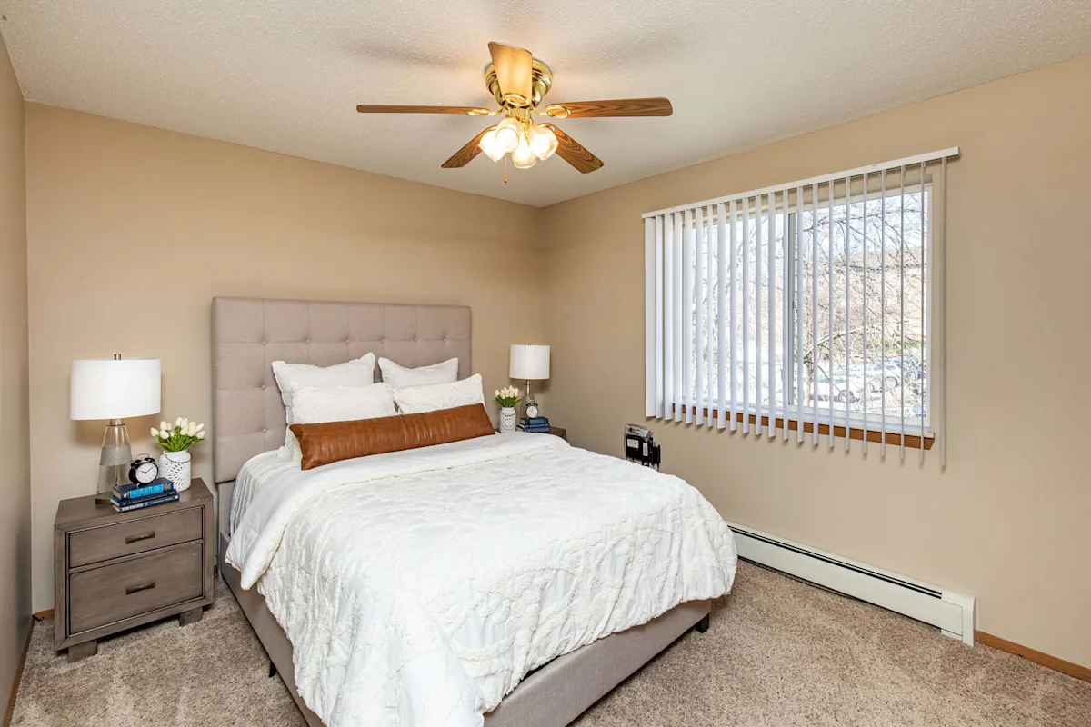 Bedroom with ceiling fan and window coverings