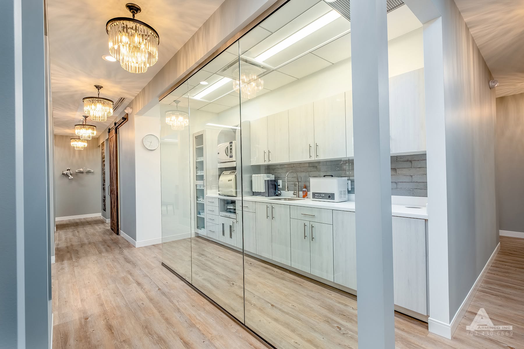 Modern sterilization center and hallway at Pure Dental office featuring glass walls, cabinetry, and  