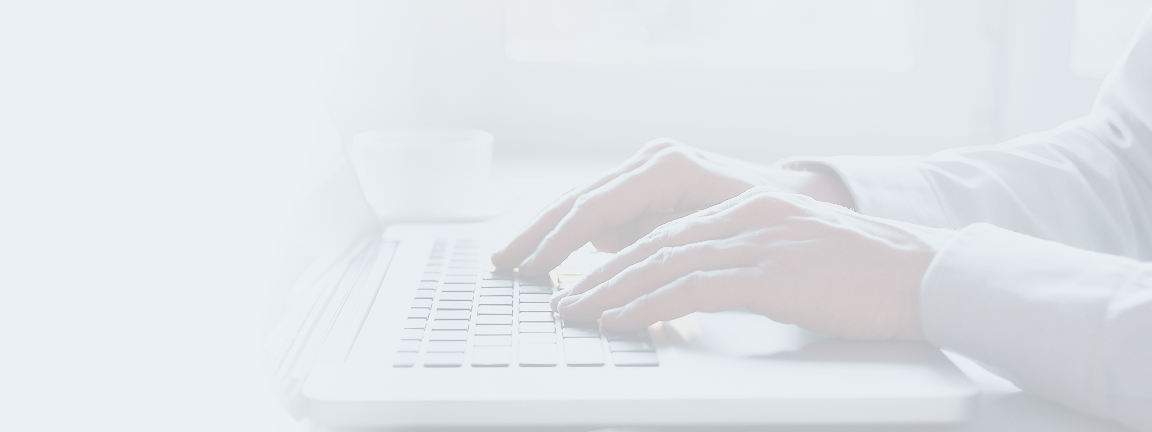 Close-up of a person typing on their laptop.