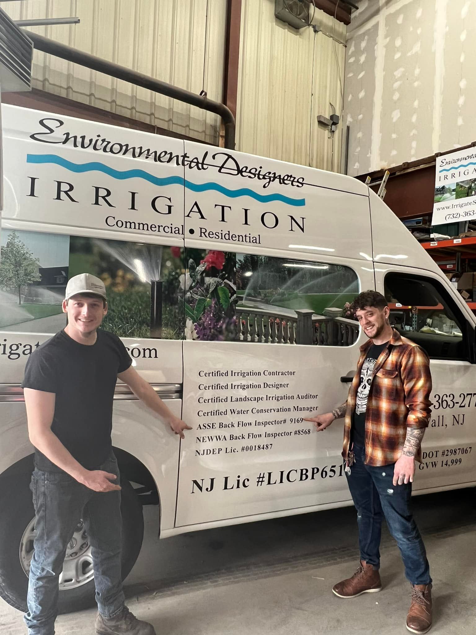 Two team members standing proudly in front of the Environmental Designers Irrigation company service van.