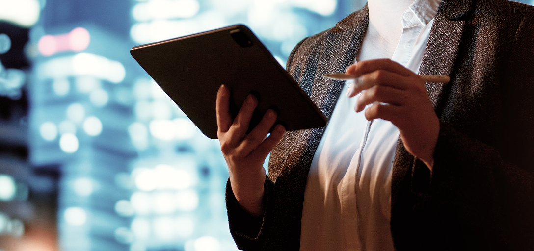 A close-up of a wealth professional holding their tablet in one hand and stylus in the other.