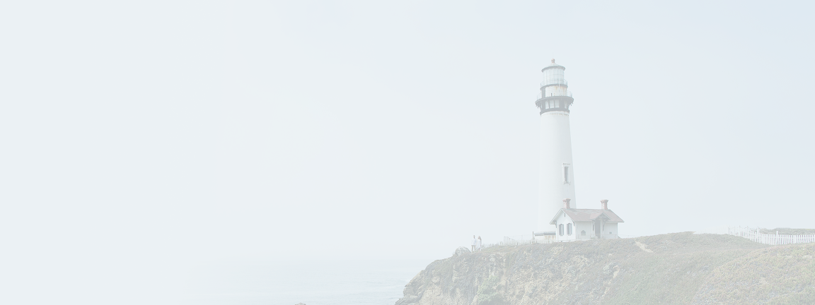 A lighthouse on top of a hill against the backdrop of a cloudy daytime sky.