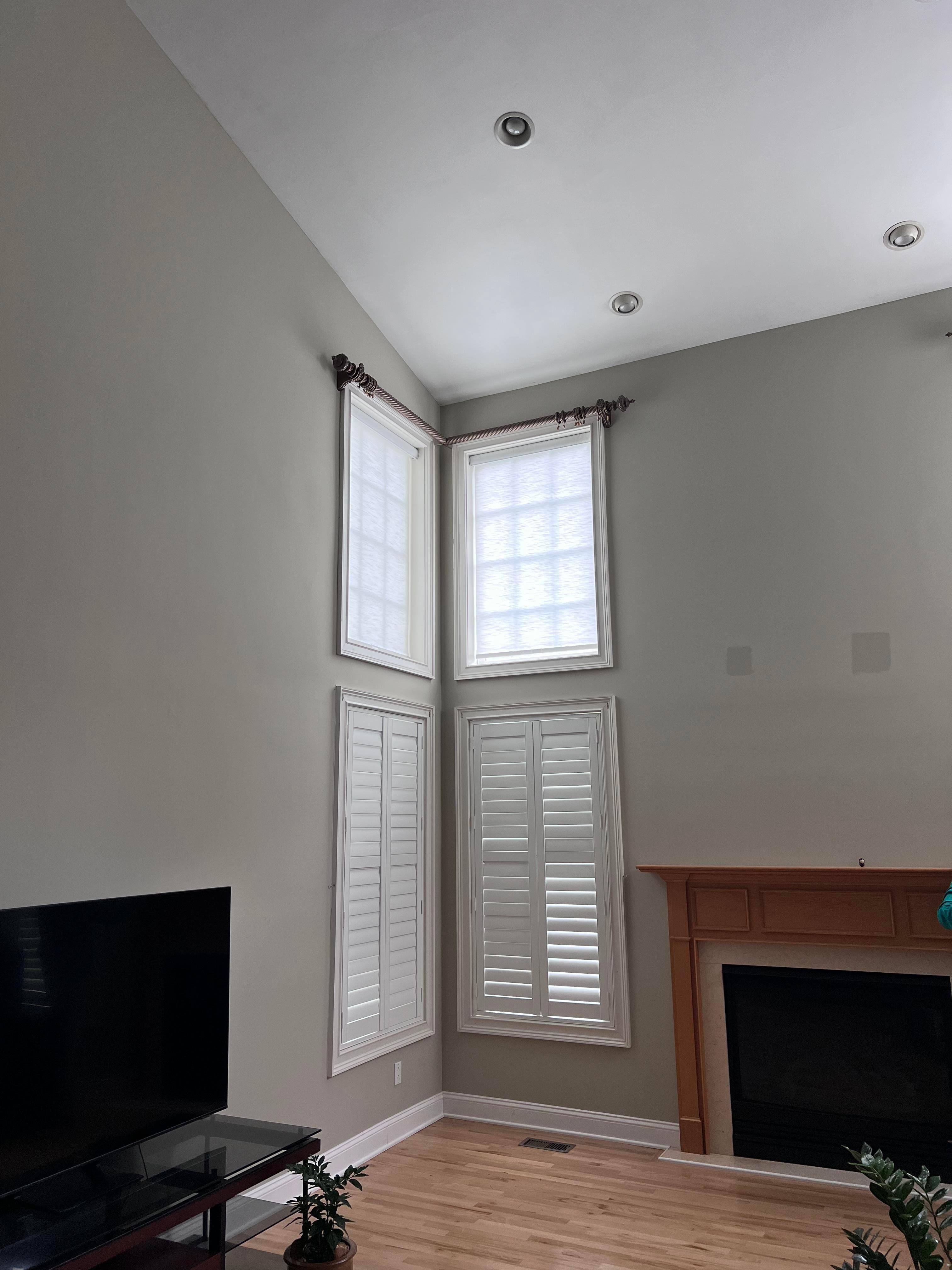 Stacked windows can be difficult to decide what types of treatments to use. This is a combination of roller shades and shutters.