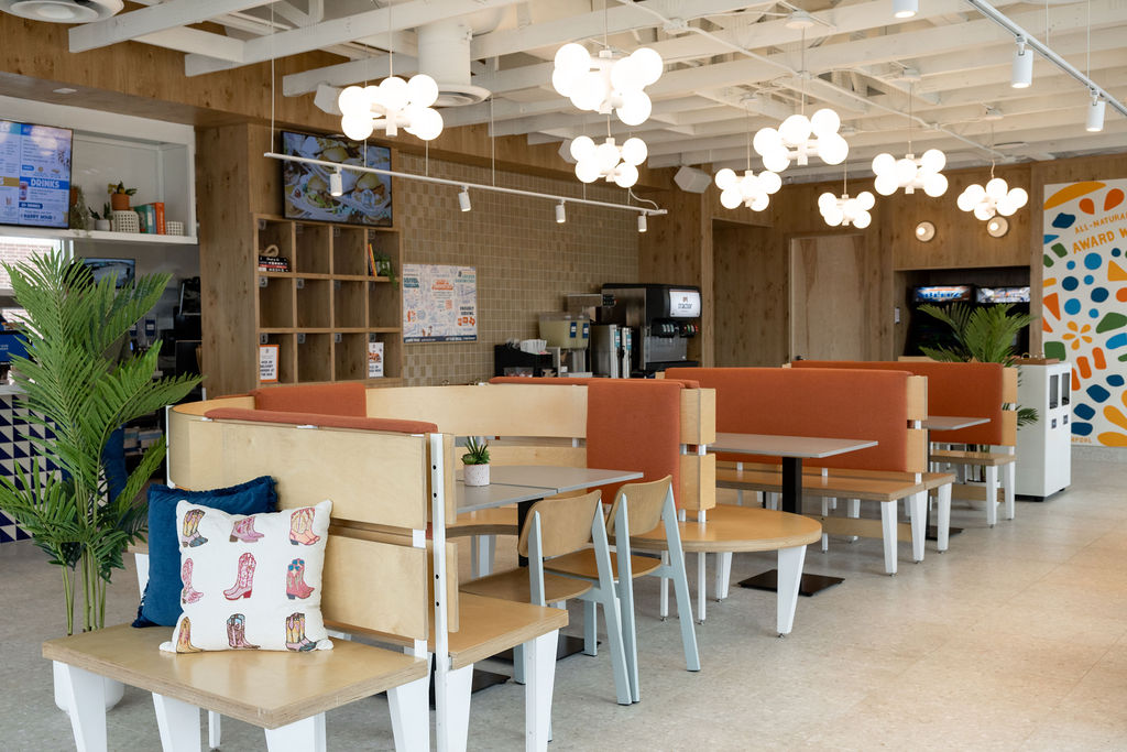 Interior of Birdcall McKinney, showing off the booths in the dining room with the free-play arcade game in the background.