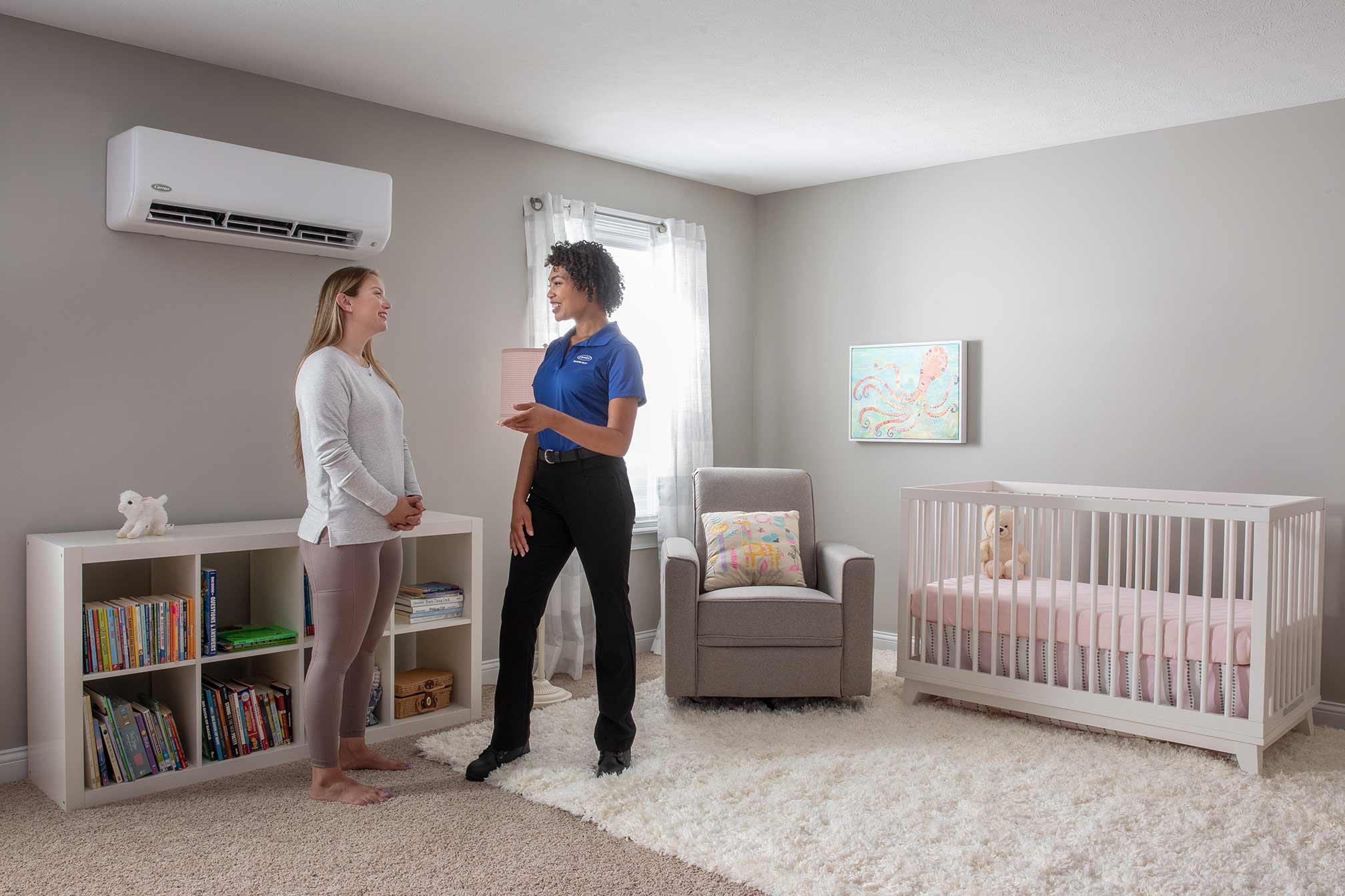 A Carrier dealer talks with a woman after a ductless mini split installation