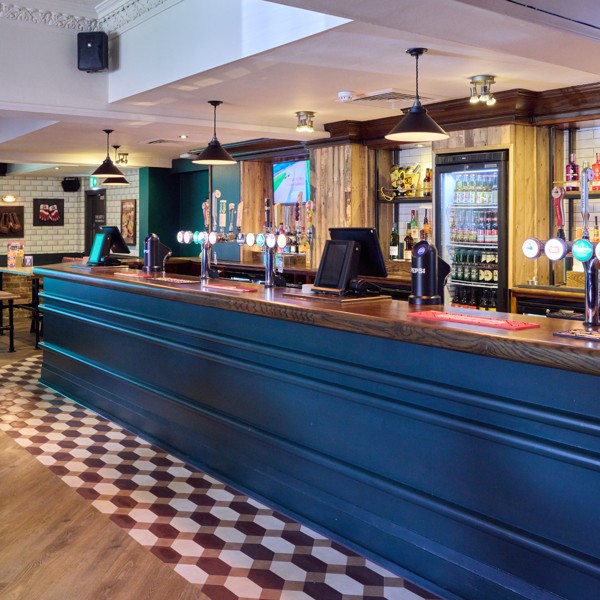 Spacious main bar area at The Tollgate featuring a wide selection of draught beers, spirits and comfortable seating.