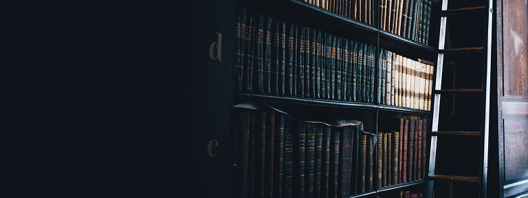 Des rangées de livres reliés en cuir sur les étagères d'une bibliothèque.