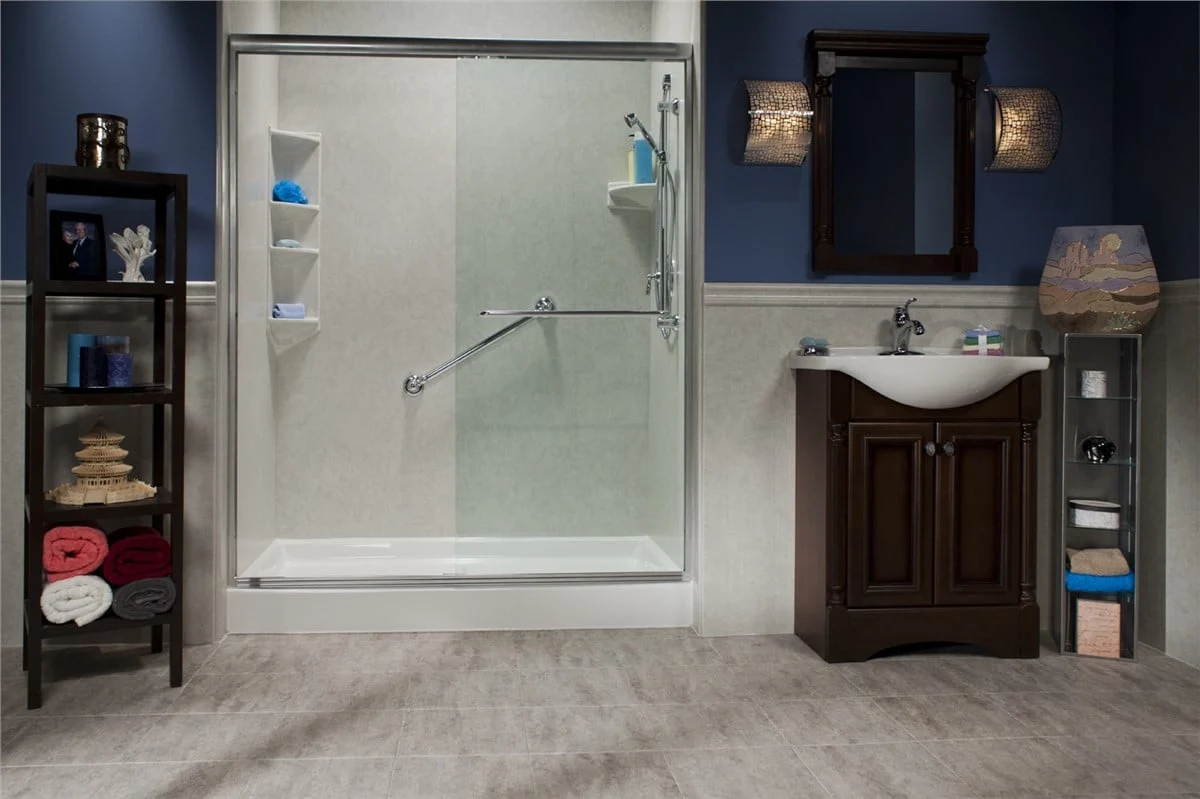 Accessible walk-in shower with glass door and grab bar in modern blue bathroom