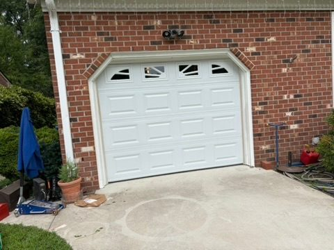 Completed residential garage door replacement by Garage Fixer, featuring a white raised-panel door w 