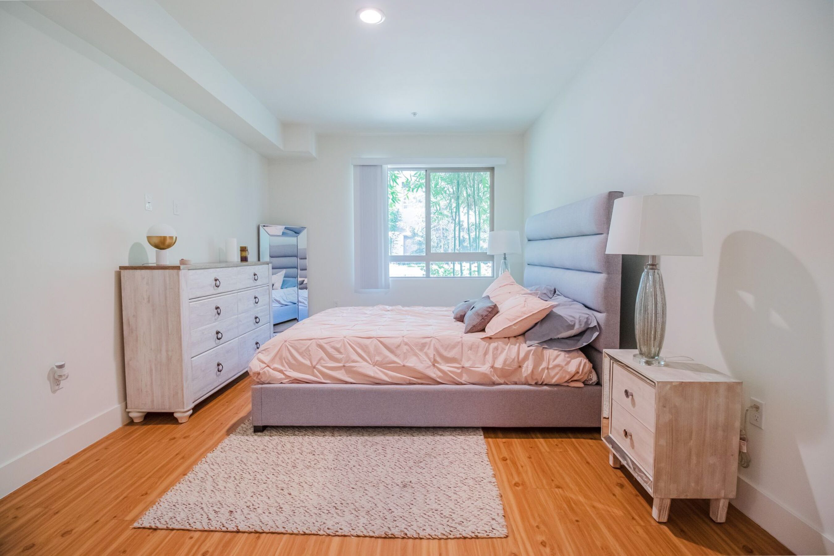 A bedroom with a bed, nightstand, and dresser.