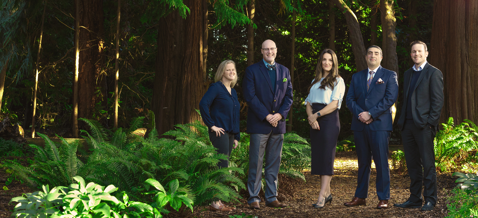 The Lonsdale, Nozari & Andrews Private Wealth team standing side by side in a forest.