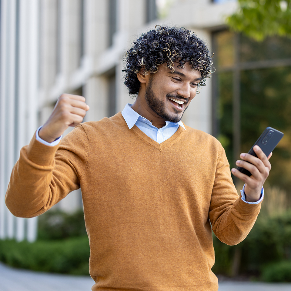 A happy man looking at his phone