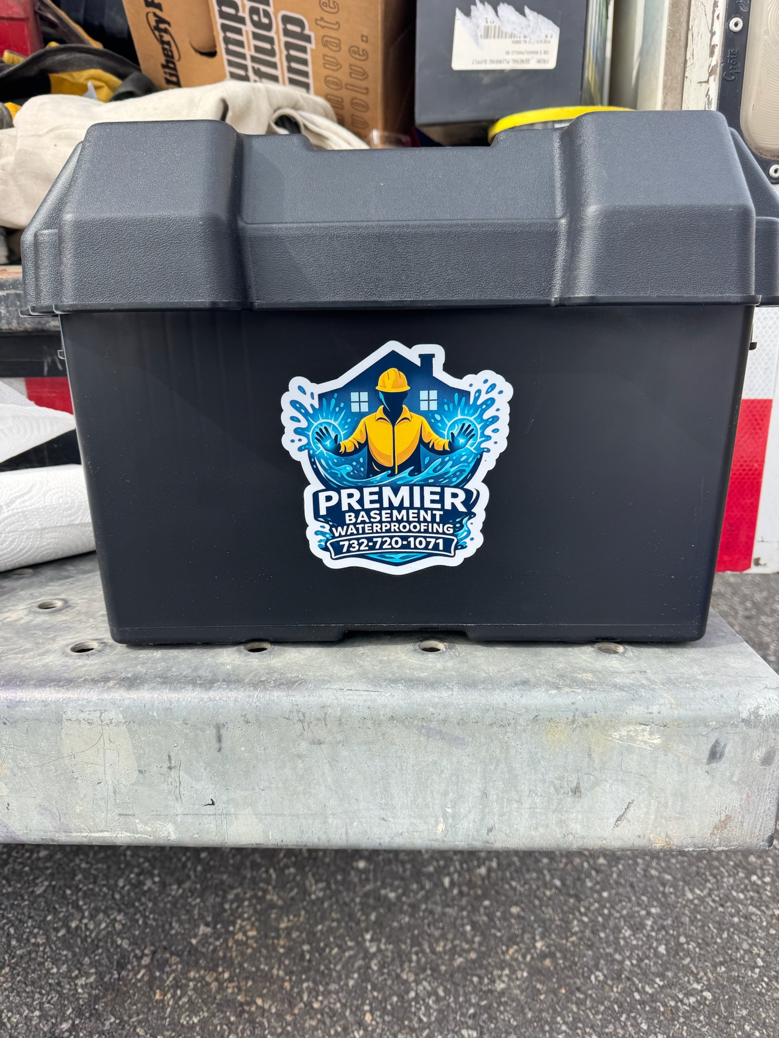 Photo of a Premier Basement Waterproofing-branded equipment setup, showing the company logo and waterproofing service branding.