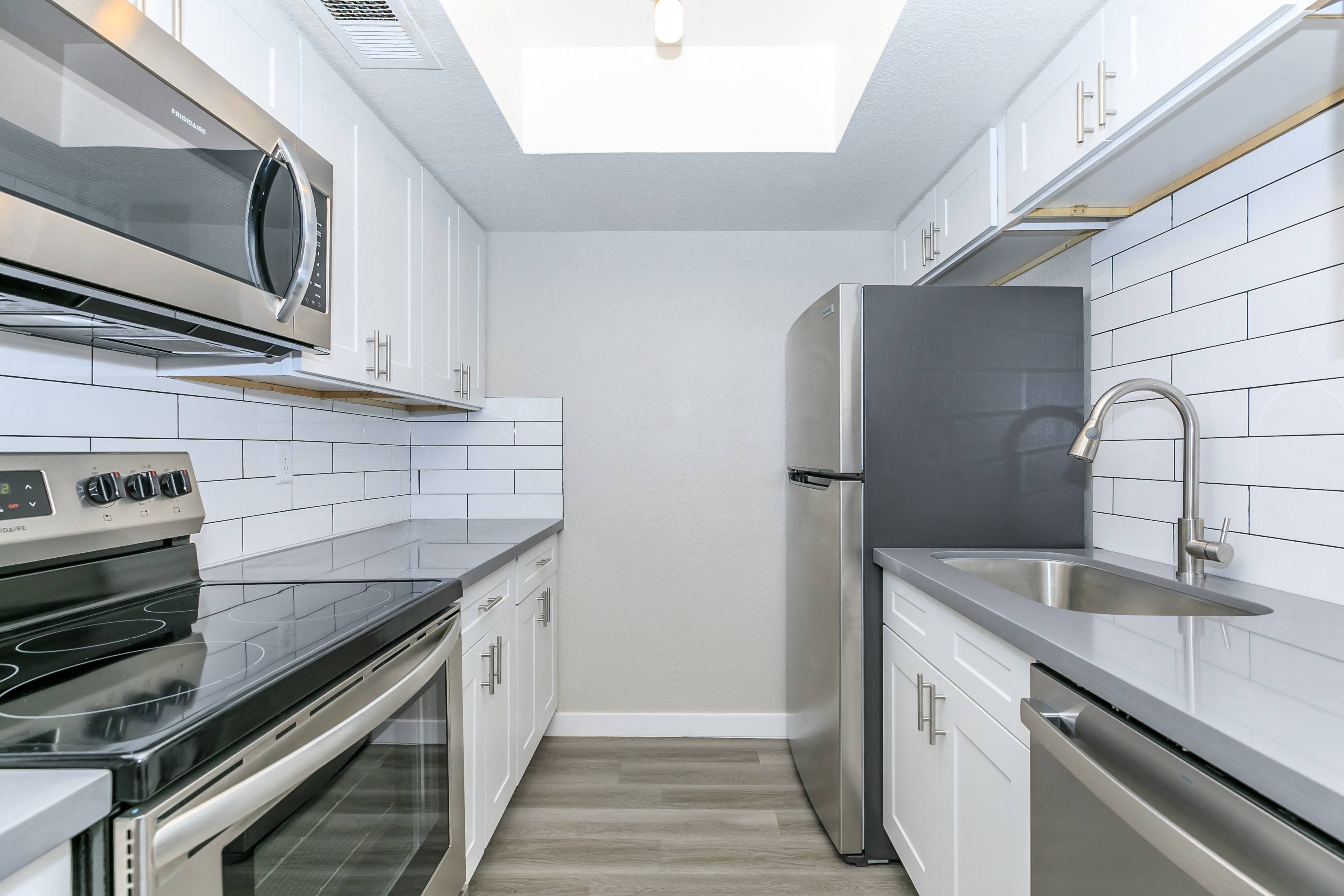 a kitchen with stainless steel appliances and white cabinets