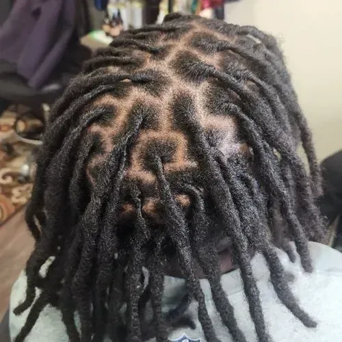 Freshly retwisted locs with geometric scalp parting and defined sections, emphasizing precision styl 