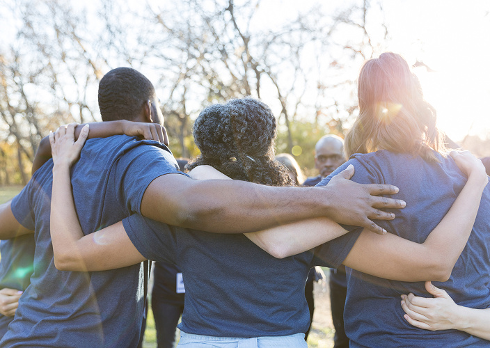 A group of people huddled together while volunteering.