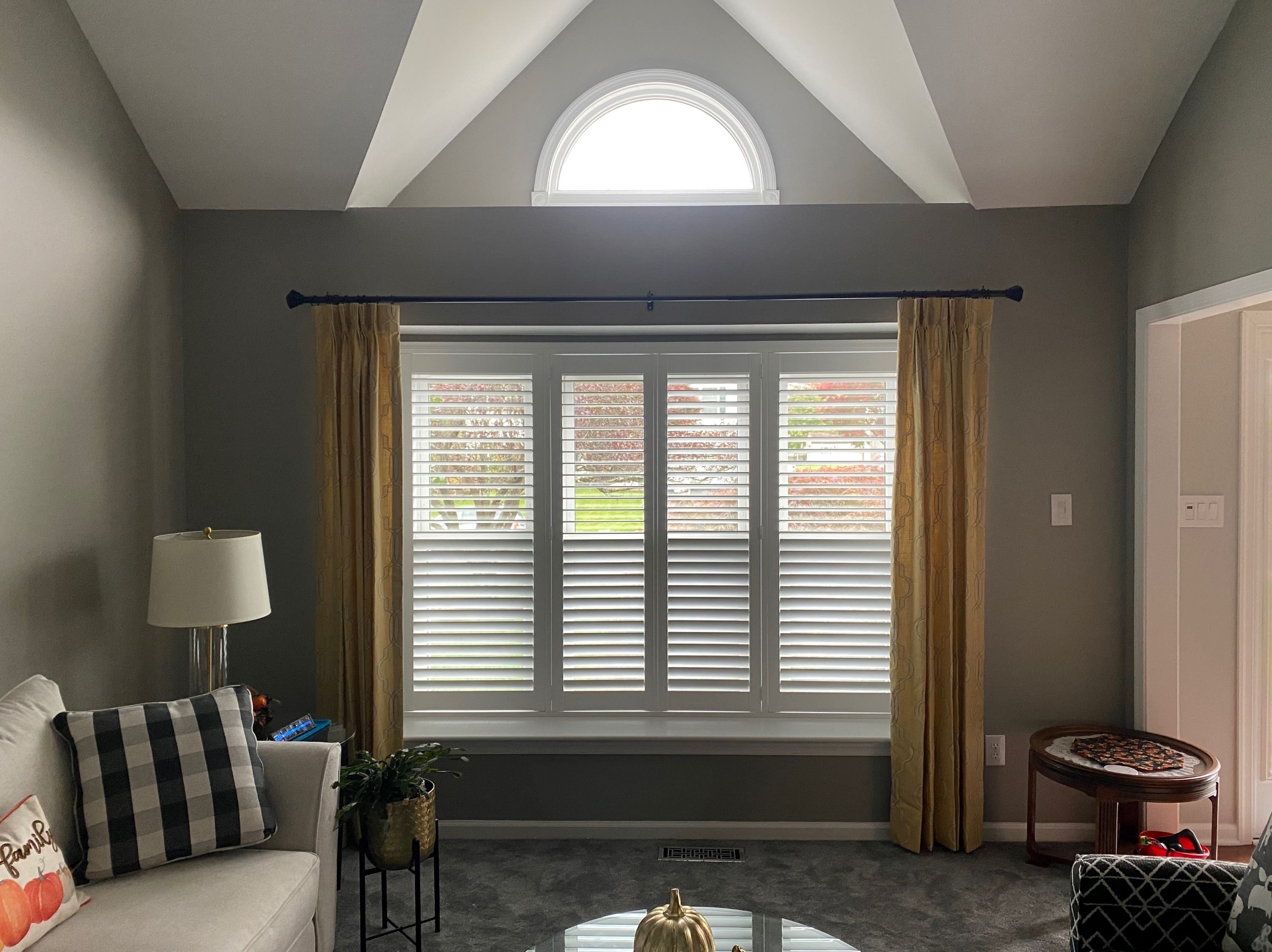 Fully dressed window with custom draperies, hardware and plantation shutters to add privacy to this livingroom.