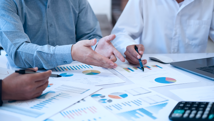 People examining charts on a table.