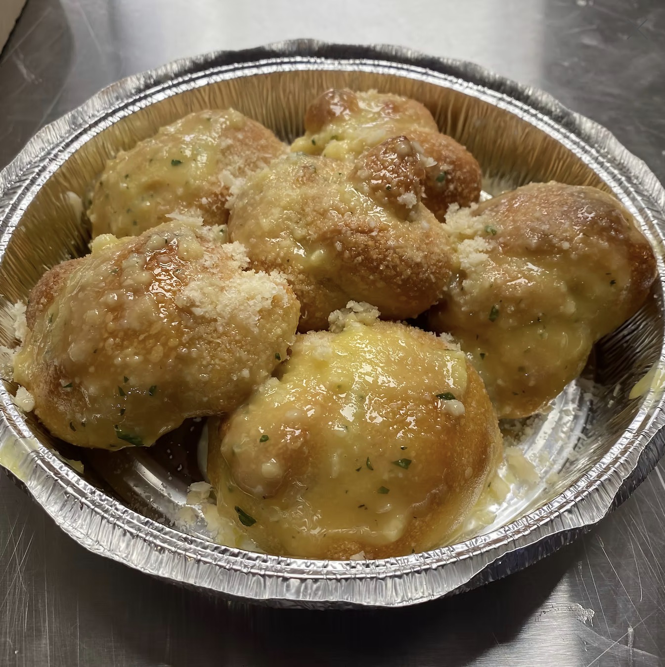 Six homemade dough knots topped with melted butter, minced garlic, grated Parmesan cheese, and freshly chopped parsley. Served with a side of homemade marinara sauce.