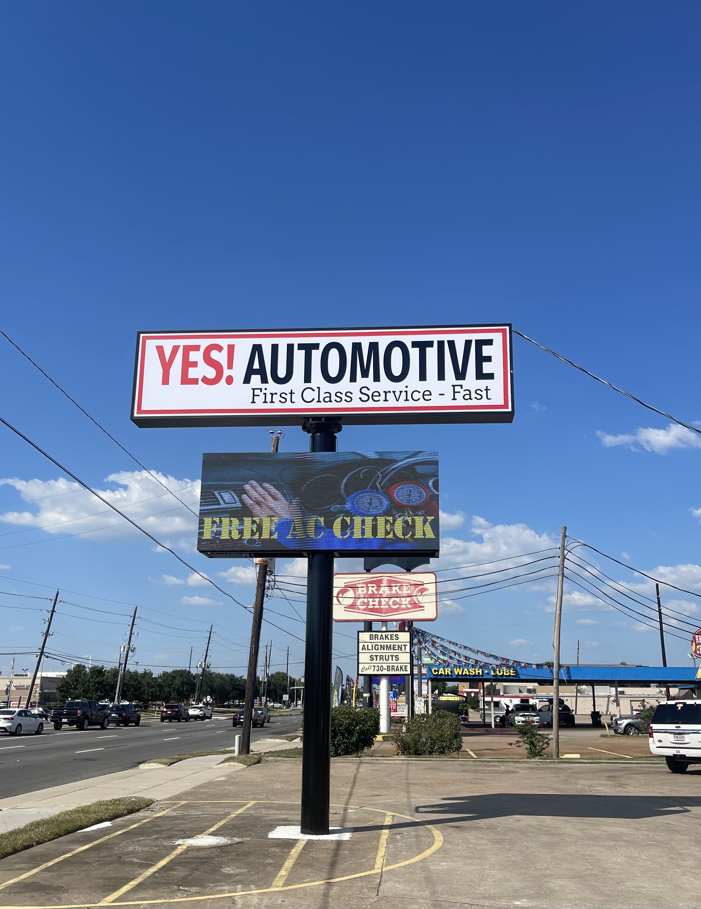 Street-side pole sign for Yes! Automotive along Highway 6 N in Houston, Texas, displaying clear business branding to motorists and nearby traffic.