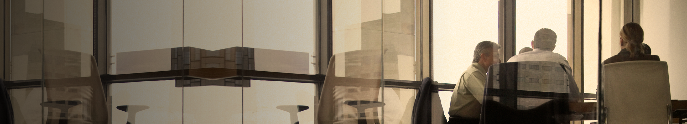 Professionals working around a boardroom table.