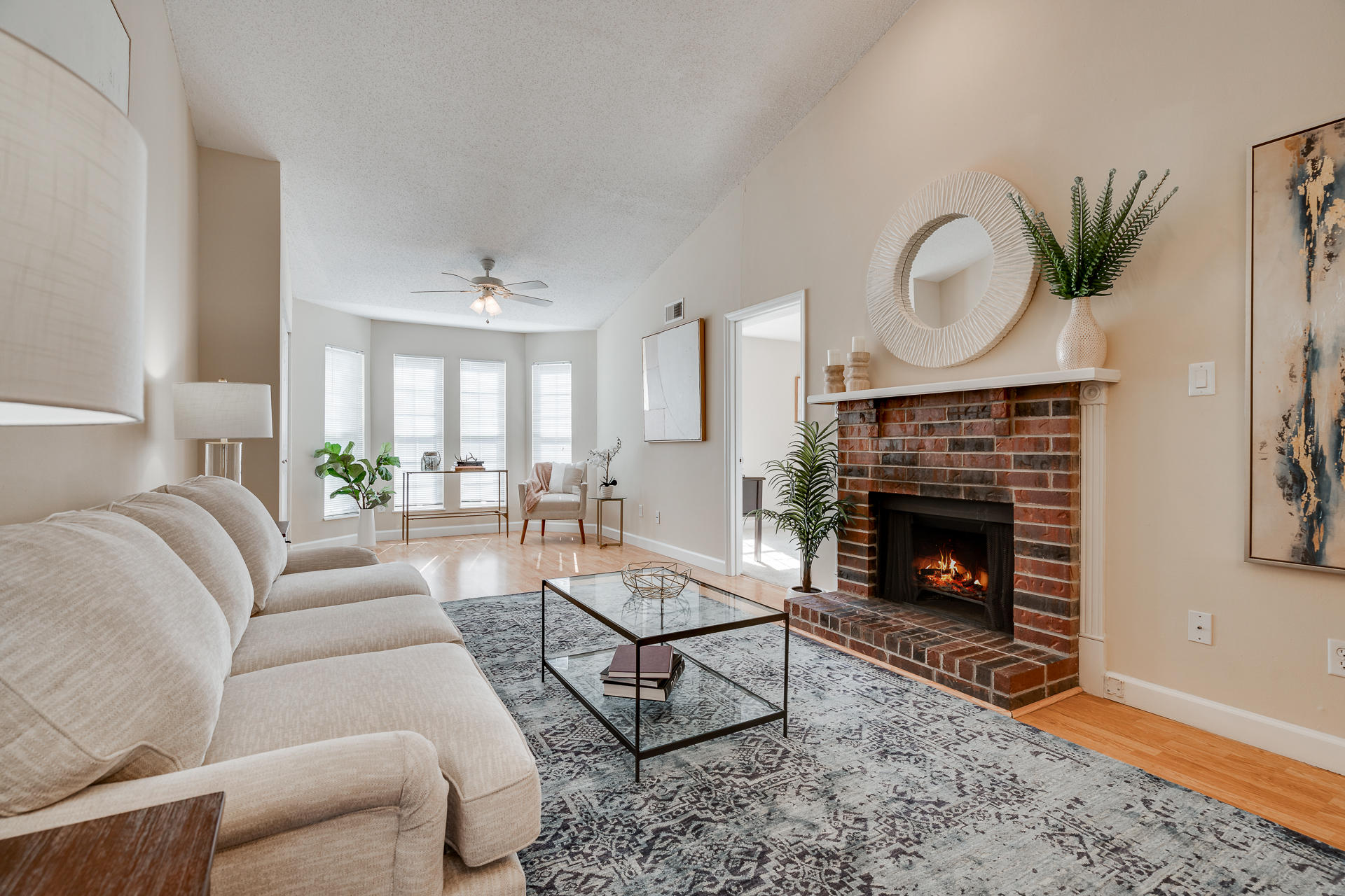 Living Room With Wood-Style Flooring, Bay Windows & Fireplace