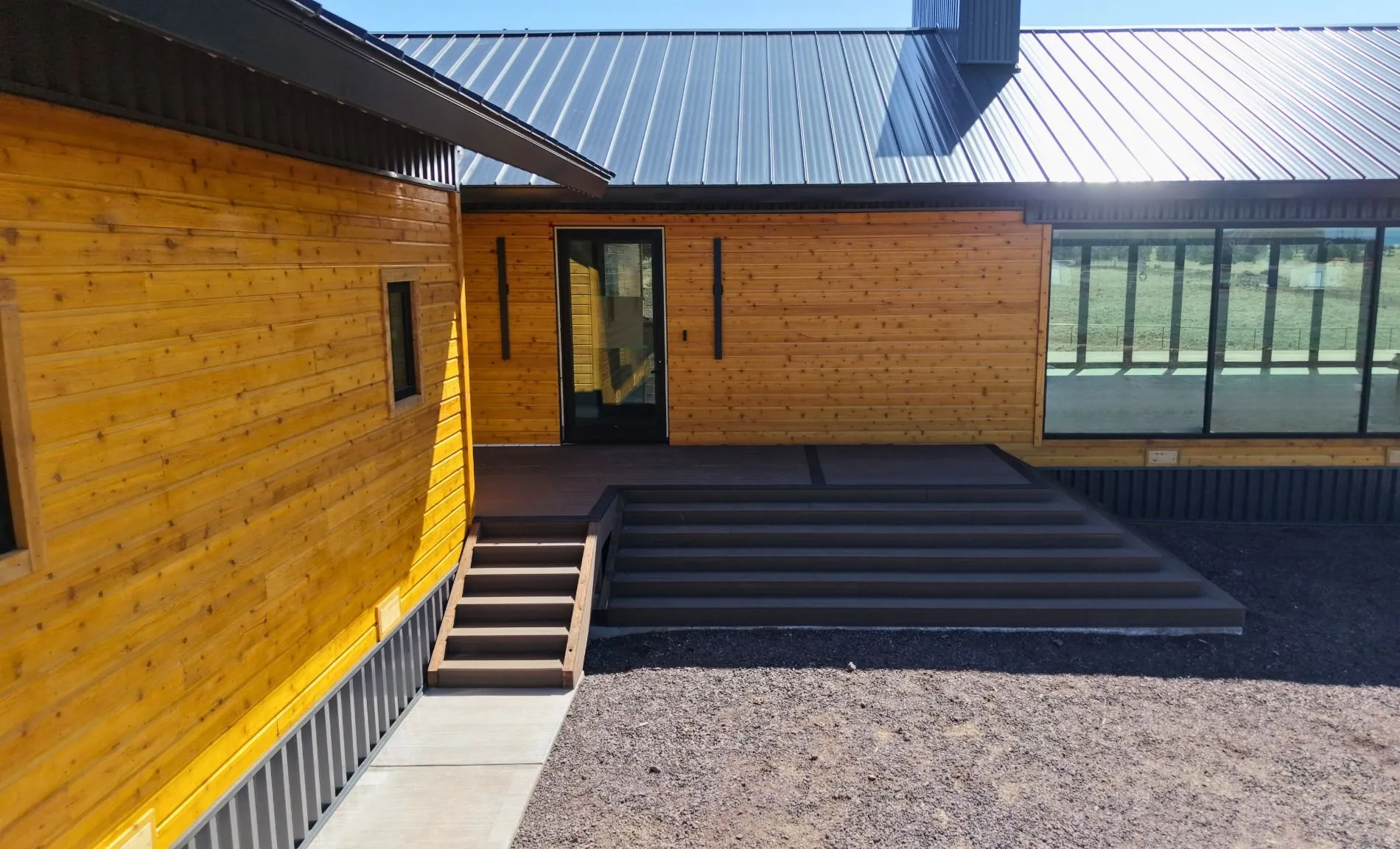 Contemporary home featuring natural wood siding, metal roofing, and clean architectural lines. Built with durable materials to provide long-term performance and modern curb appeal.