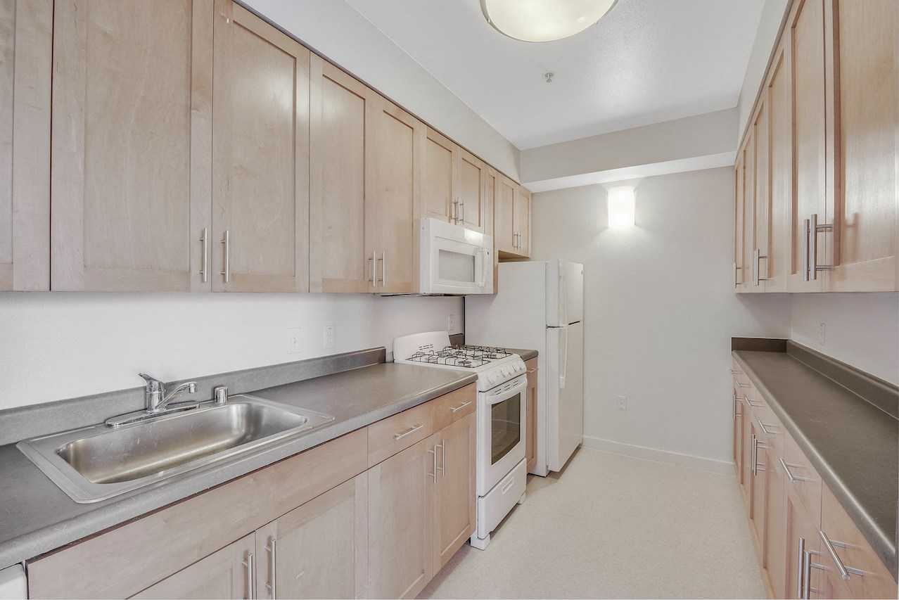 A kitchen with wooden cabinets and a white refrigerator. 