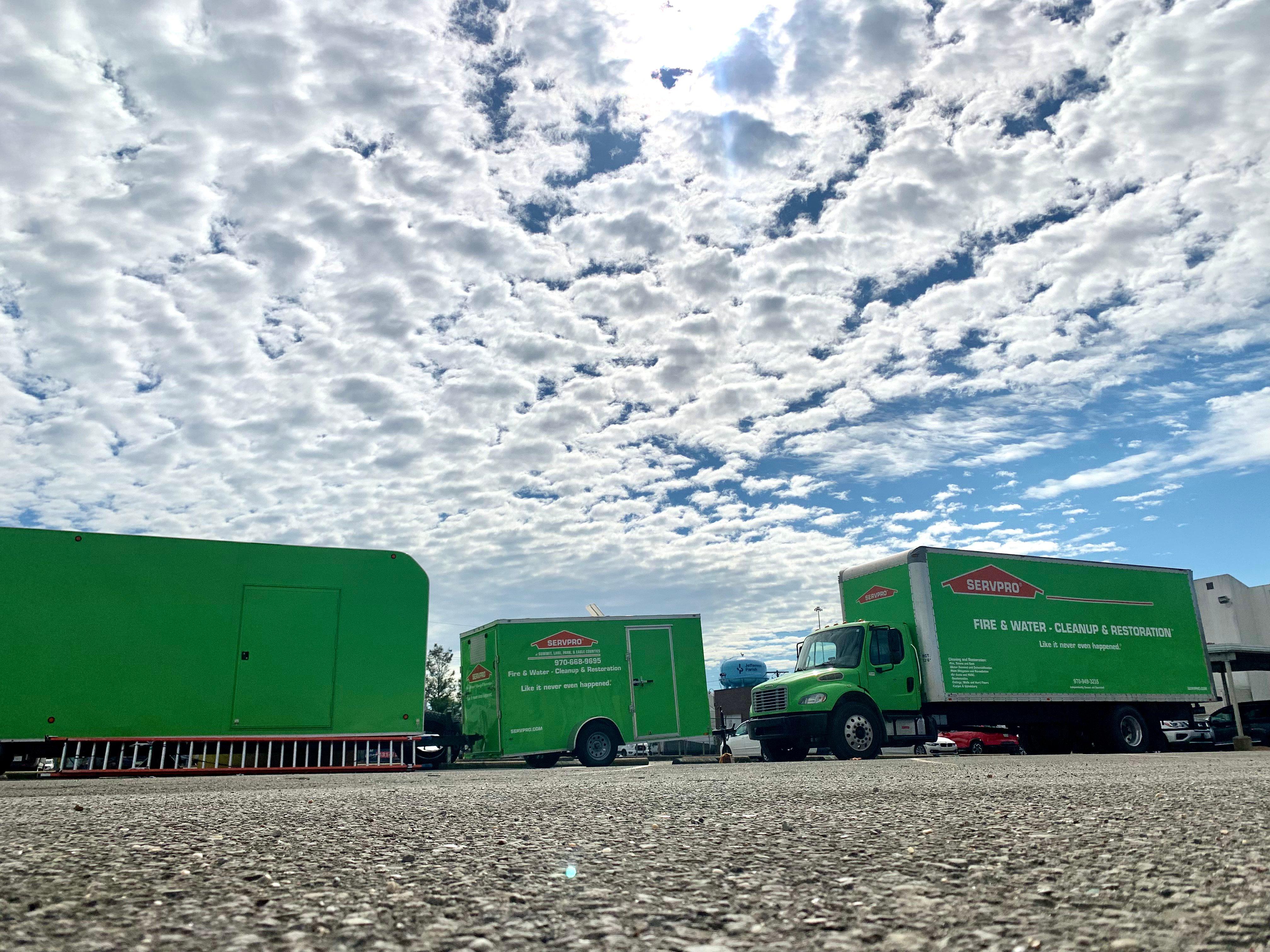 SERVPRO trucks using an adjacent parking lot to park extra vehicles for a large job.