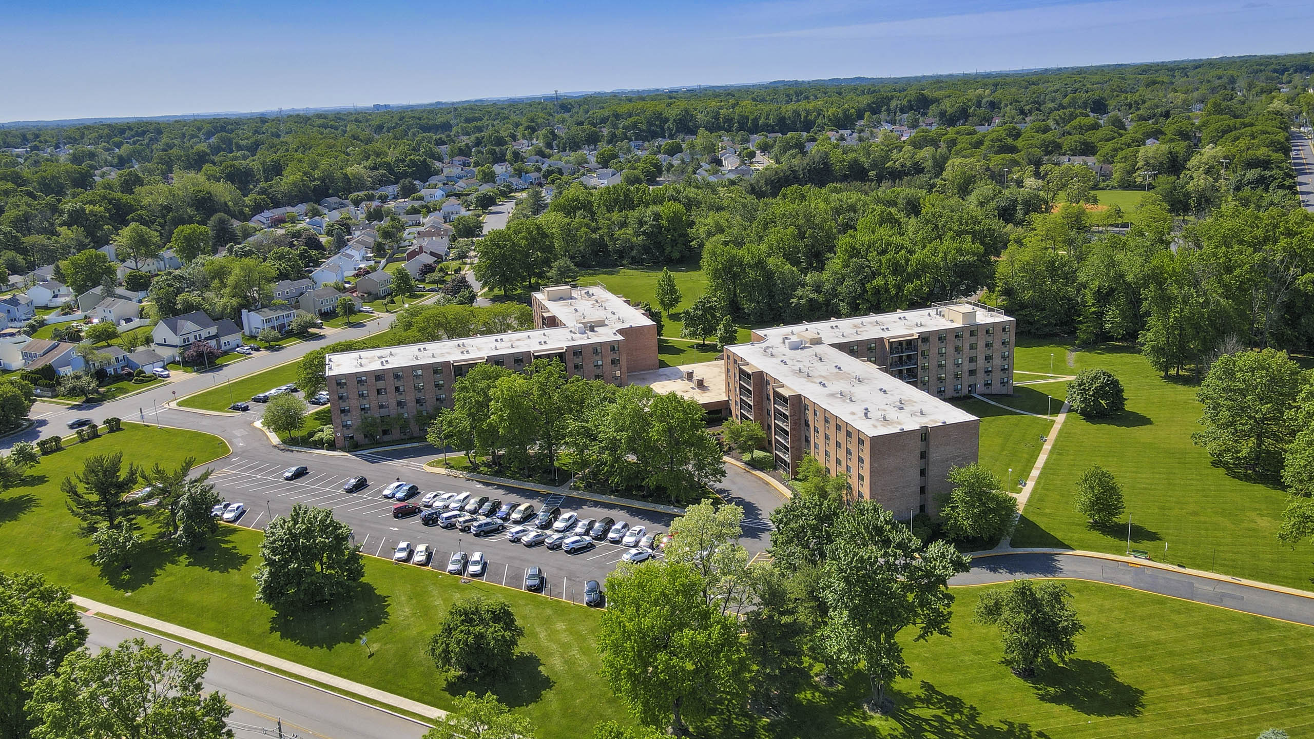 A large building complex with a parking lot in front.