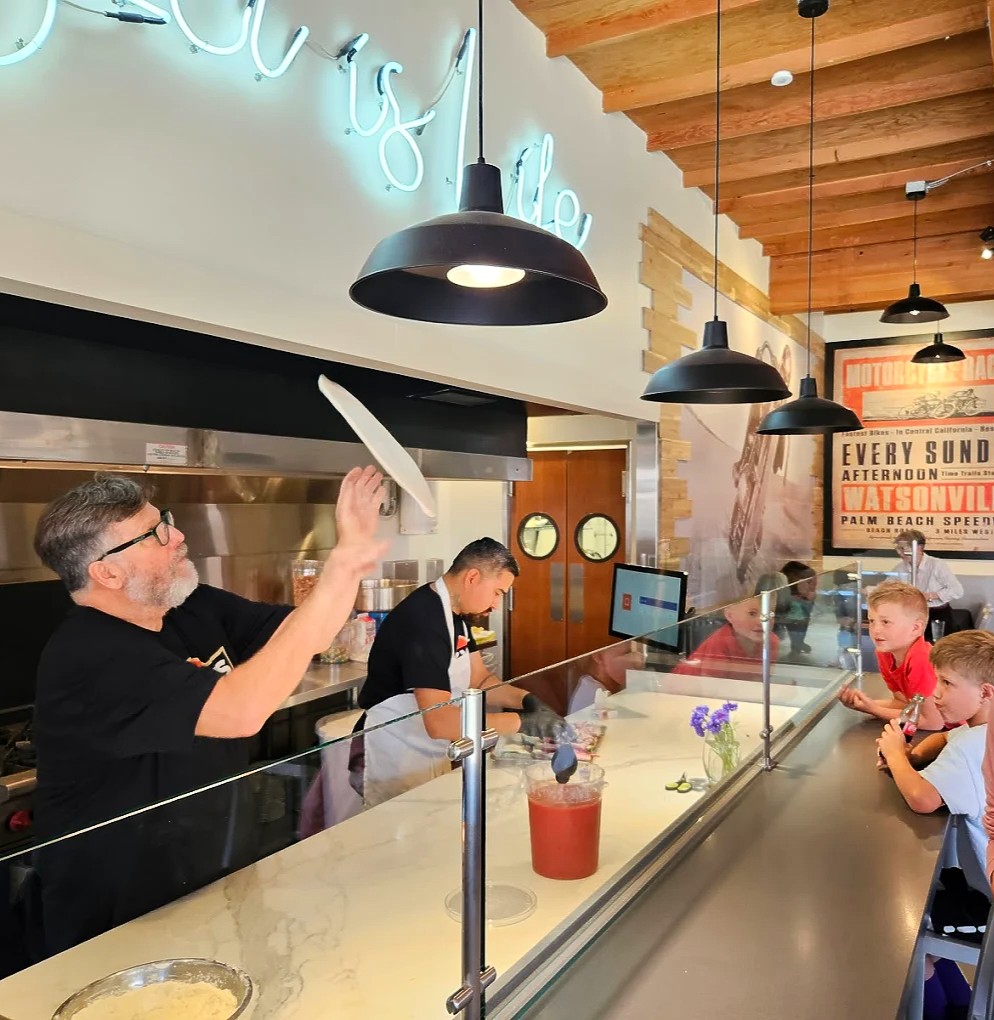 Owner Tim Silva tossing pizza dough
