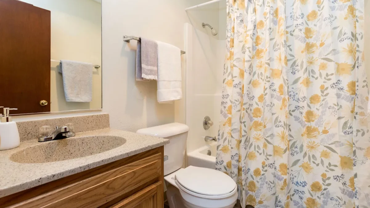 A bathroom with a toilet, sink, and shower curtain