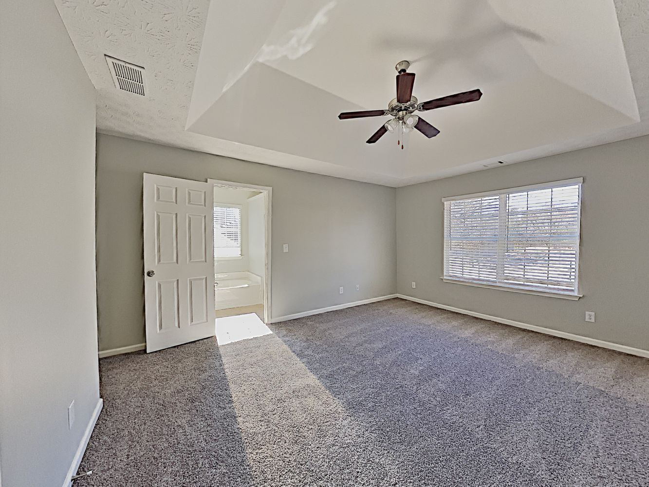 Spacious bedroom with vaulted ceiling and fan at Invitation Homes Atlanta.