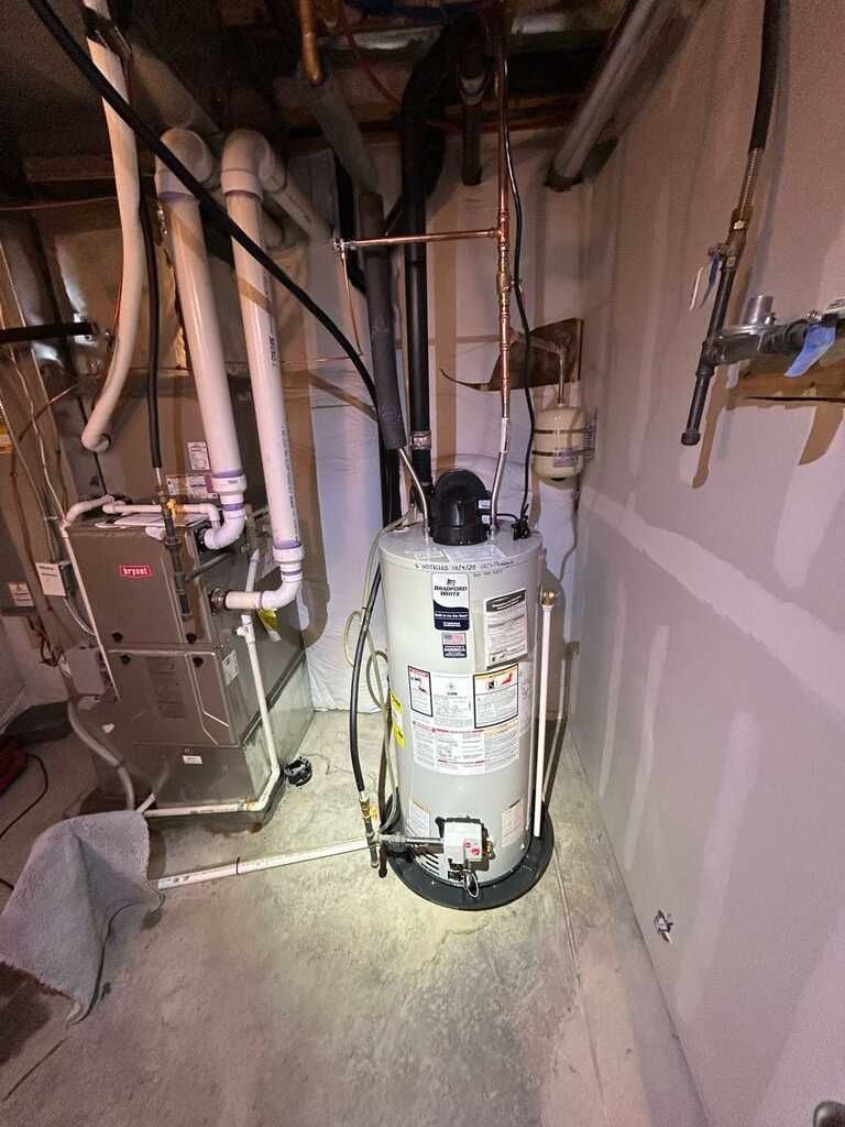 Residential utility room contains a traditional tank water heater beside HVAC equipment, venting, PV 