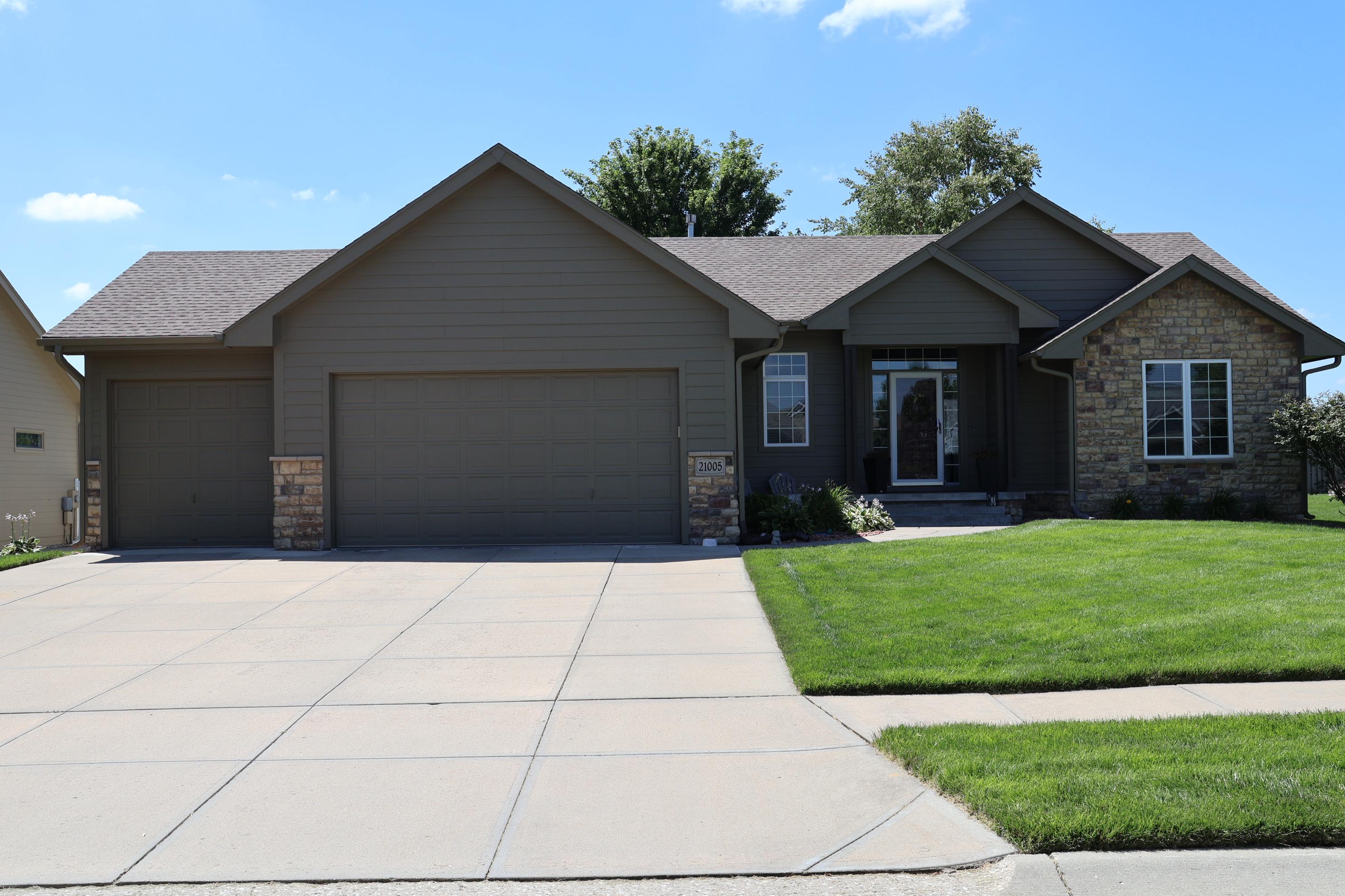 Gretna NE exterior painting project with freshly painted siding, trim, garage doors and stone accent 
