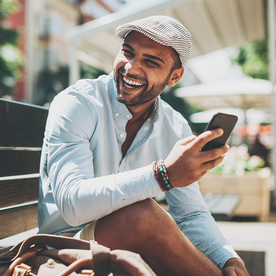 A man holding a phone and laughing.