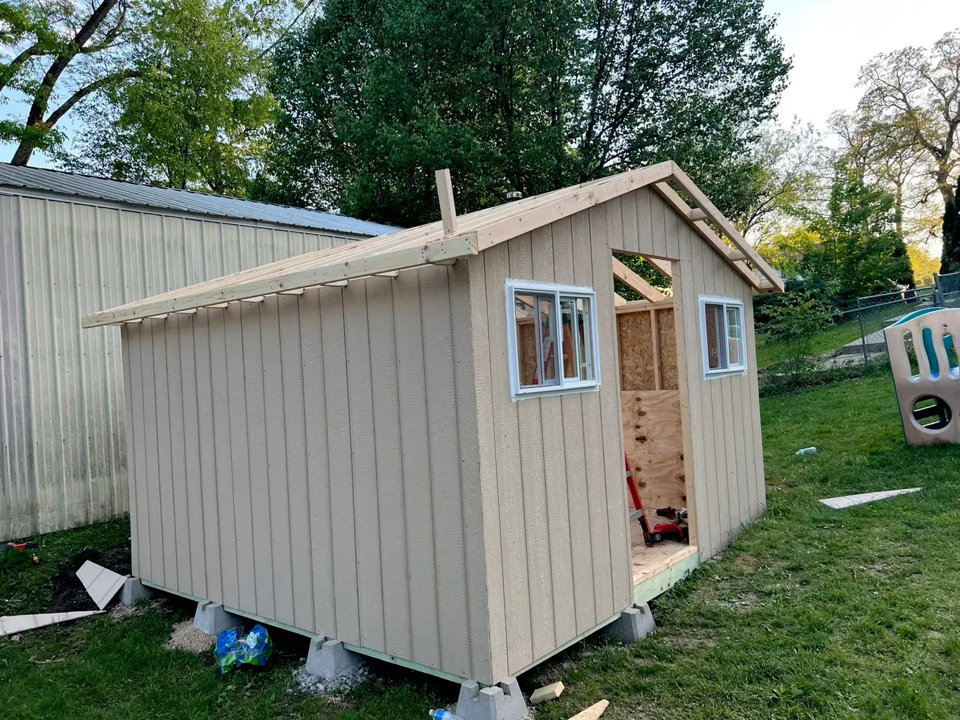 A custom backyard storage shed under construction features durable siding, quality framing, secure windows, strong roof framing, and professional craftsmanship, creating reliable outdoor storage with lasting performance and value.