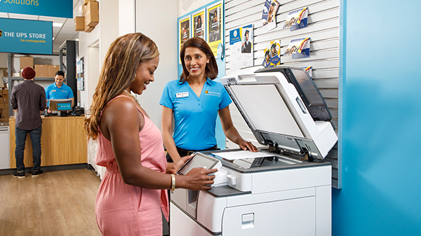 Employee assists customer at copier
