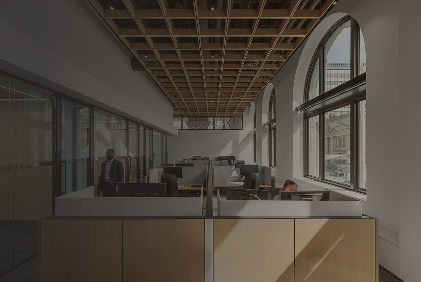 Professionals working at their desks in the modern, bright Ascendant Wealth Partners office.