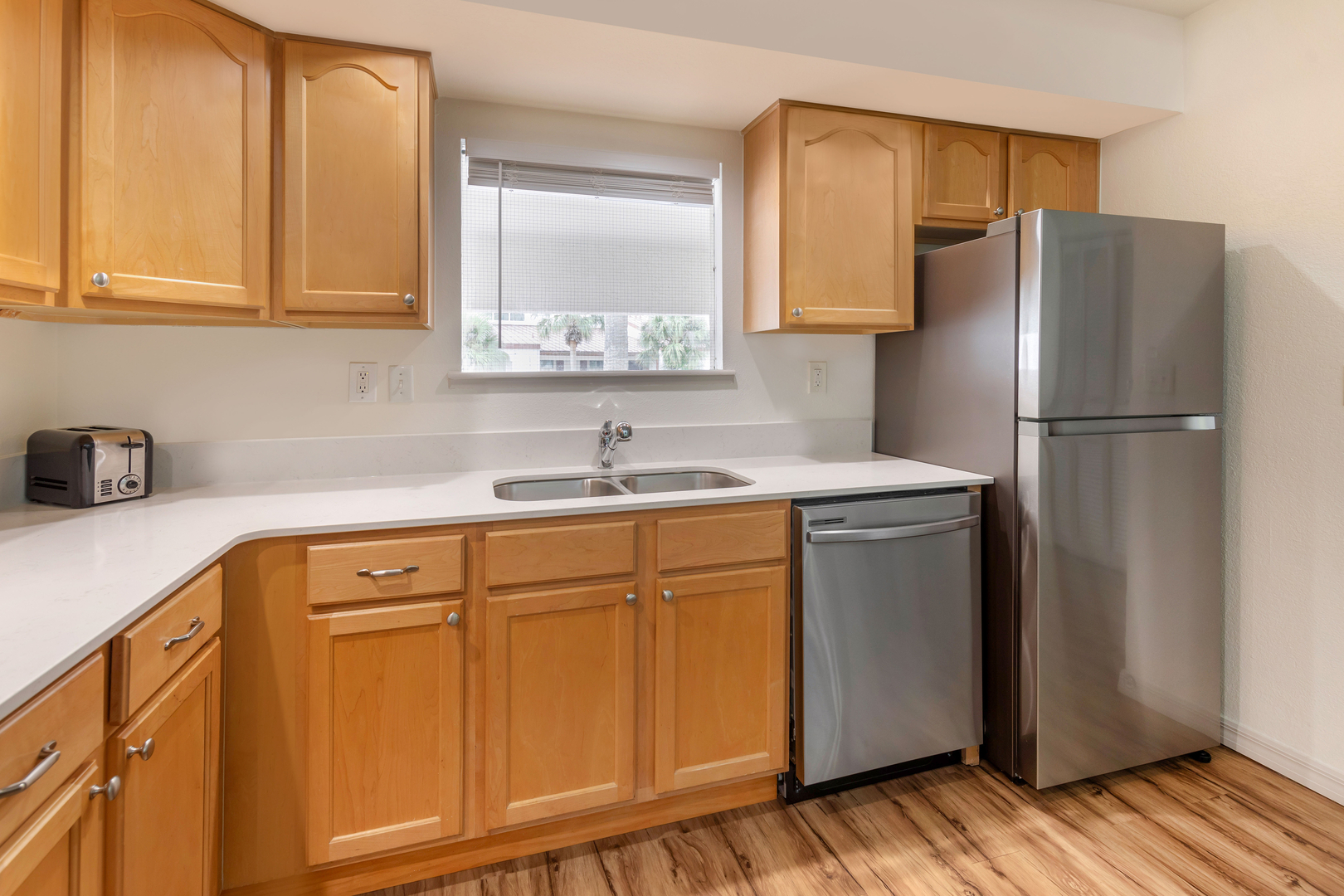 The kitchen in an accommodation at Bryan's Spanish Cove. It features a refrigerator, sink, dishwasher, and toaster.