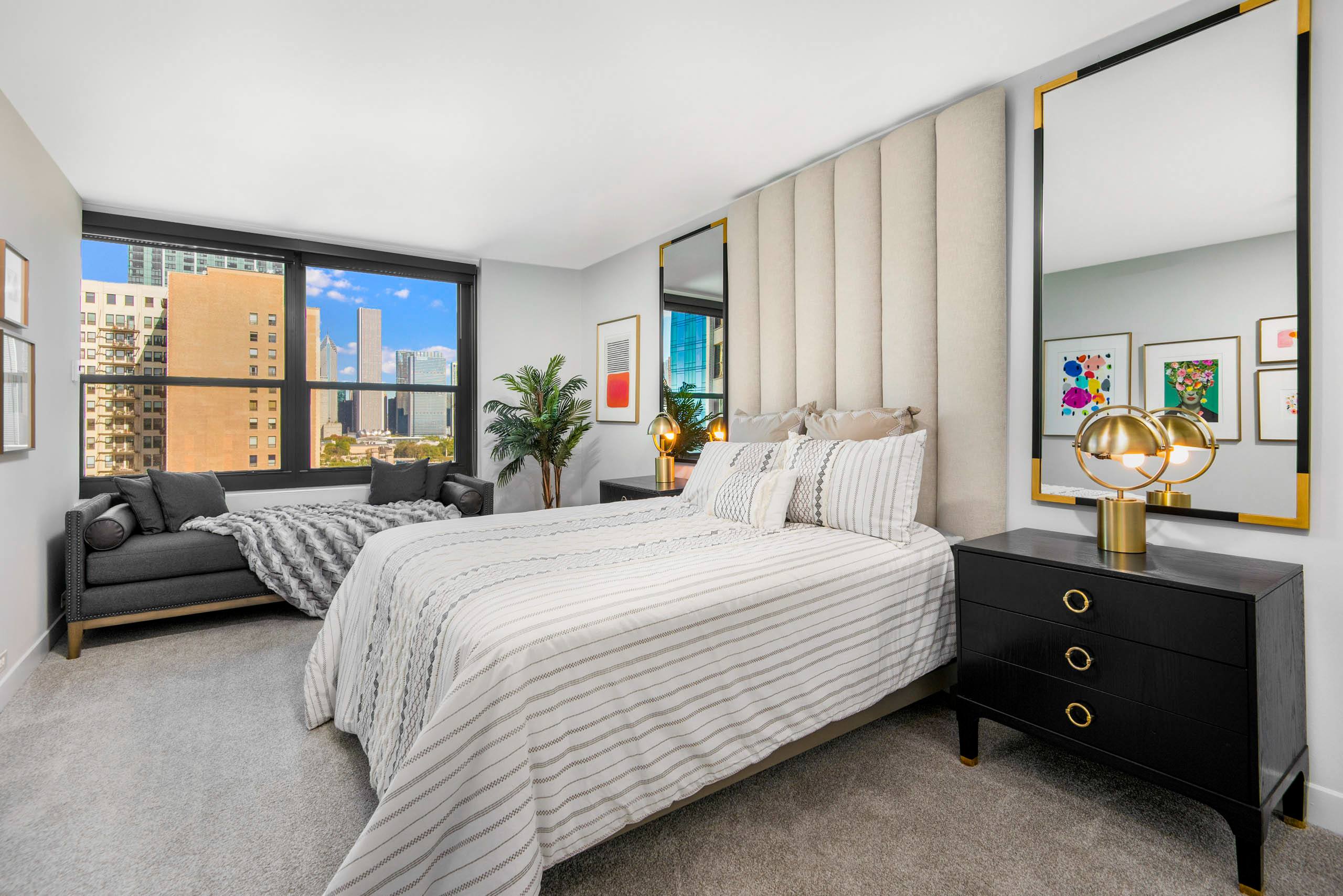 Bedroom with tall upholstered headboard and city views 