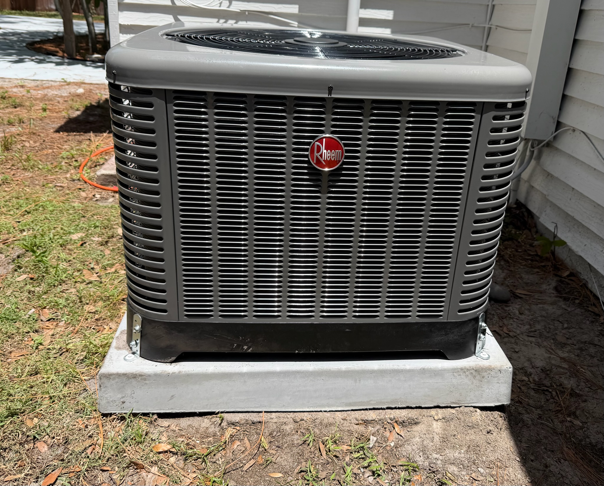 Ground-mounted air conditioning condenser unit installed on a concrete pad for efficient home coolin 