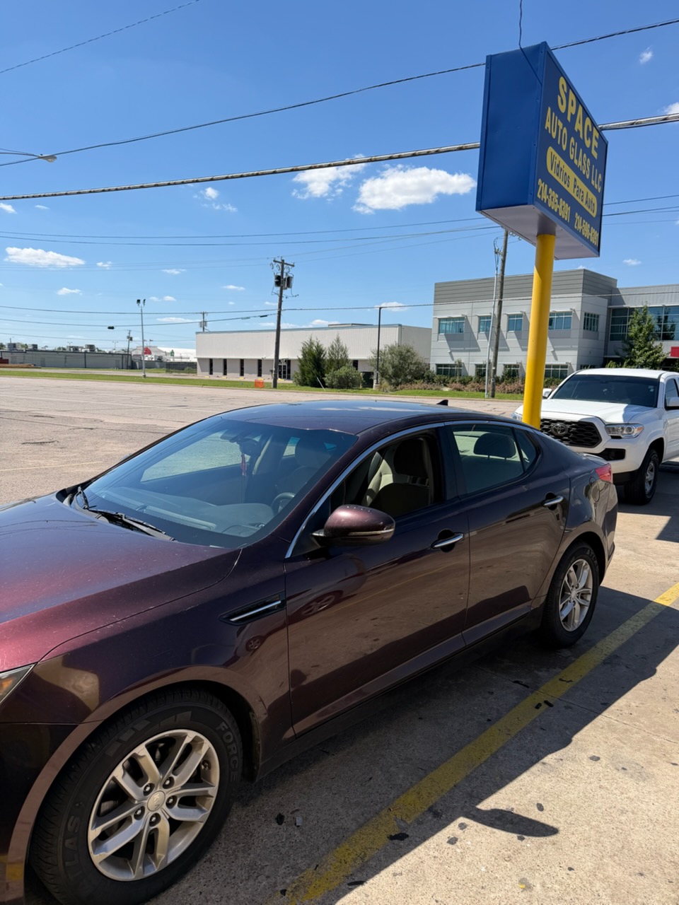 The maroon sedan is shown with a clear windshield after the damaged glass was replaced. This before-and-after example highlights windshield replacement services provided by Space Auto Glass.