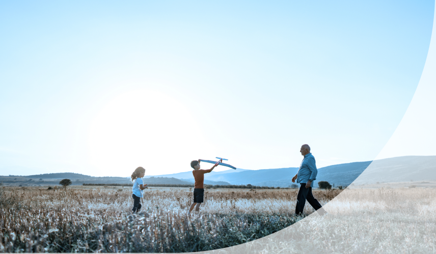 A grandfather and grandchildren playing outdoors.