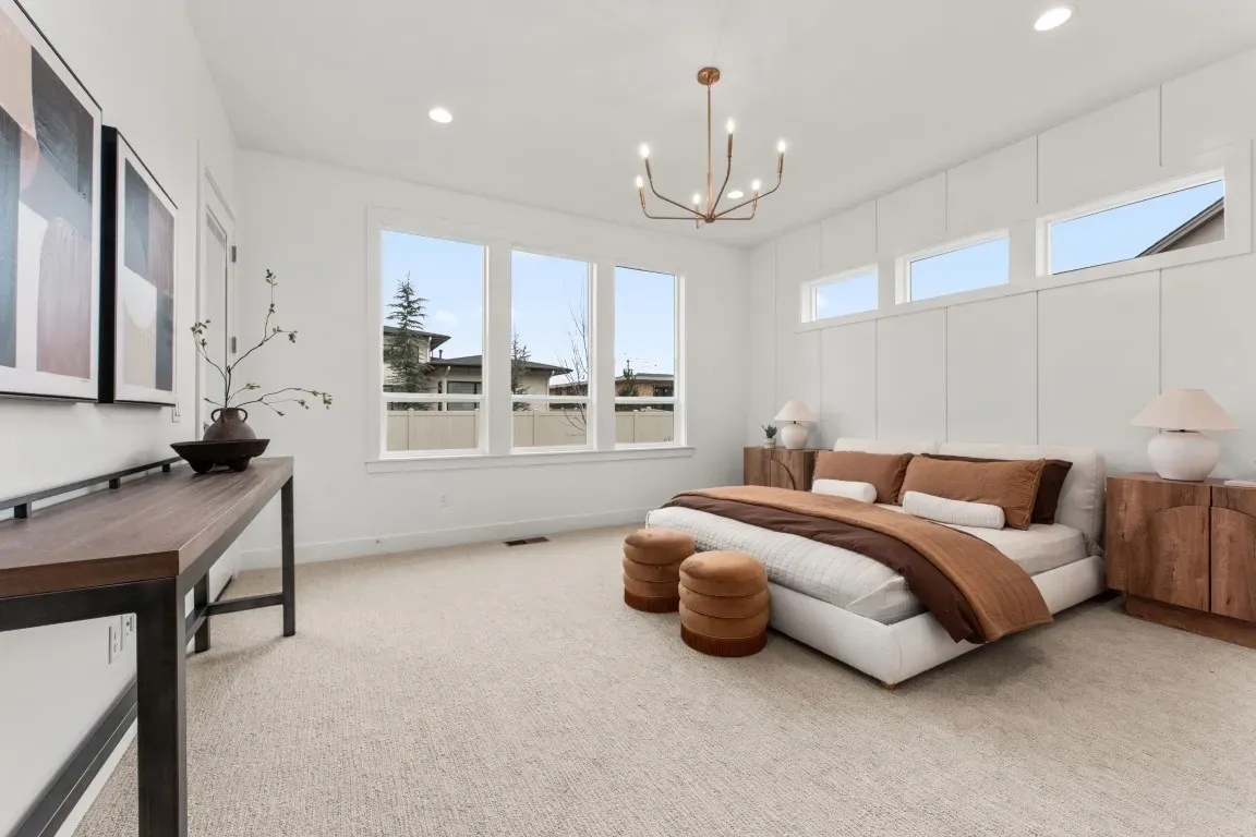 The primary suite features direct patio access and a spa-inspired bathroom, including a frameless walk-in shower, freestanding soaking tub, designer tile, and a large walk-in closet with laundry access.