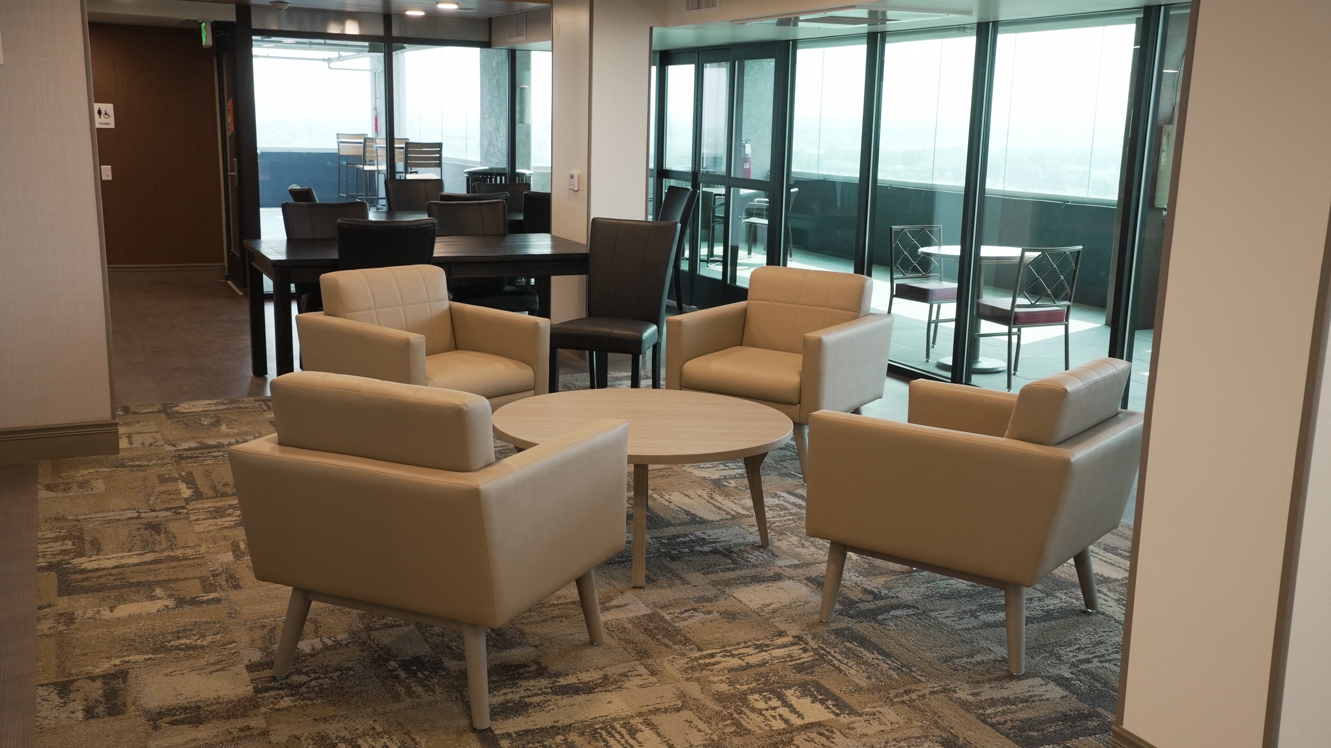 A room with a carpeted floor and a table with chairs