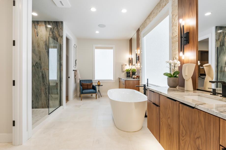 Primary bathroom boasts separate floating vanities, a free-standing tub, and large walk-in shower