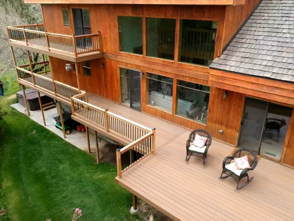 Transform your backyard into a sprawling outdoor retreat. This expansive, multi-level custom deck features low-maintenance composite decking and sleek black metal railings, providing the ultimate space for relaxation and entertaining in the Snake River Valley.